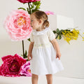 Este es un elegante vestido blanco roto con pechera, ideal para ocasiones especiales.